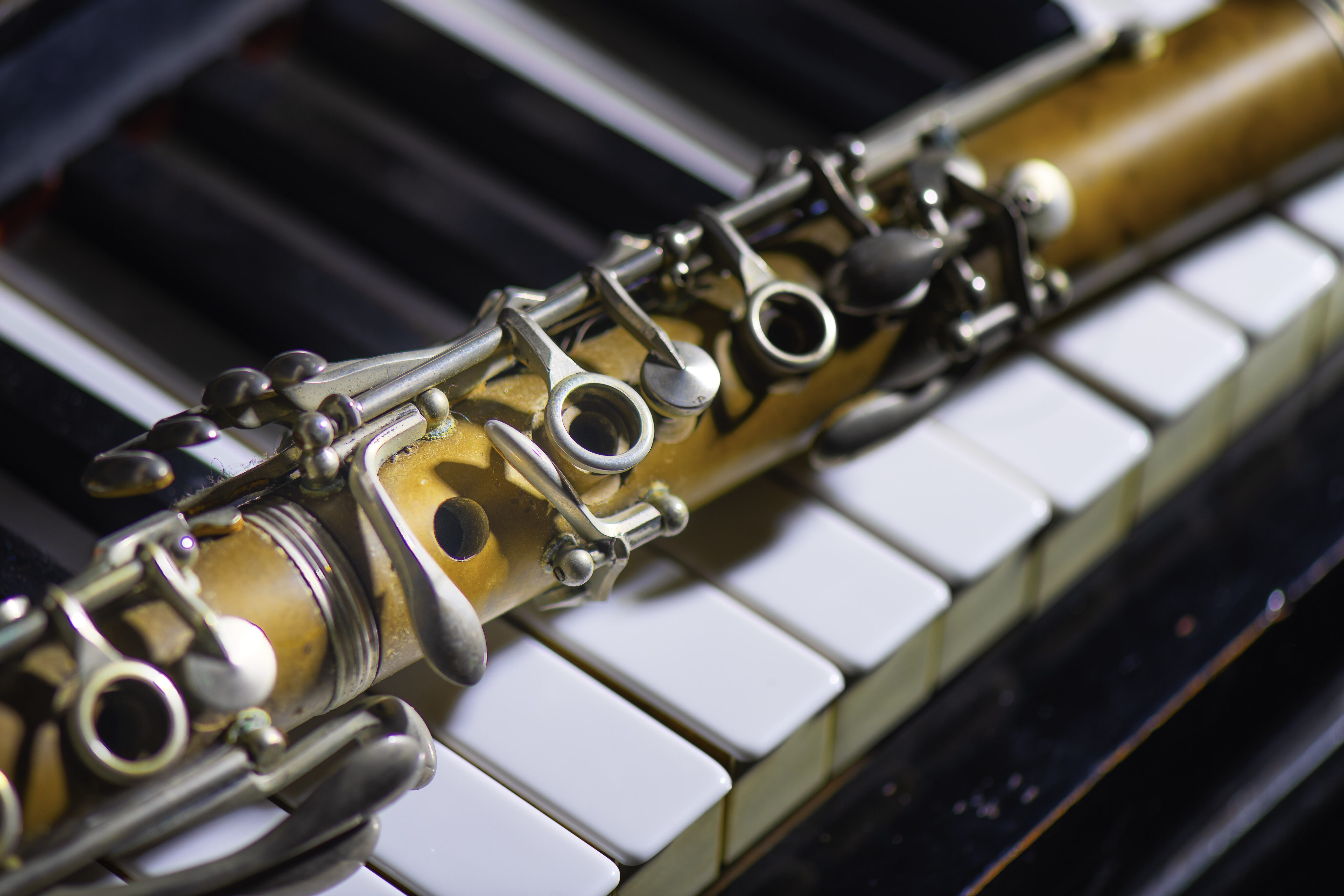 Antique clarinet leaning on piano key